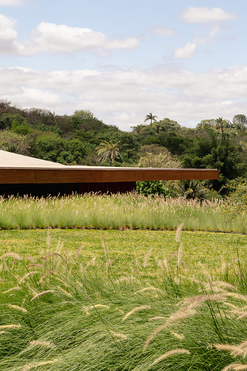 TETRO's lakeside residence in brazil vanishes into the horizon beneath triangular timber roof