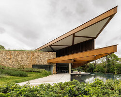 TETRO's lakeside residence in brazil vanishes into the horizon beneath triangular timber roof