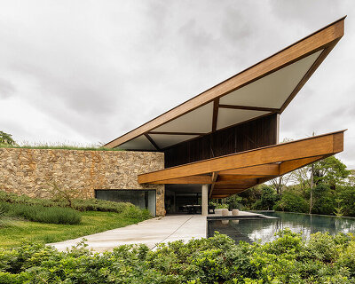 TETRO's lakeside residence in brazil vanishes into the horizon beneath triangular timber roof