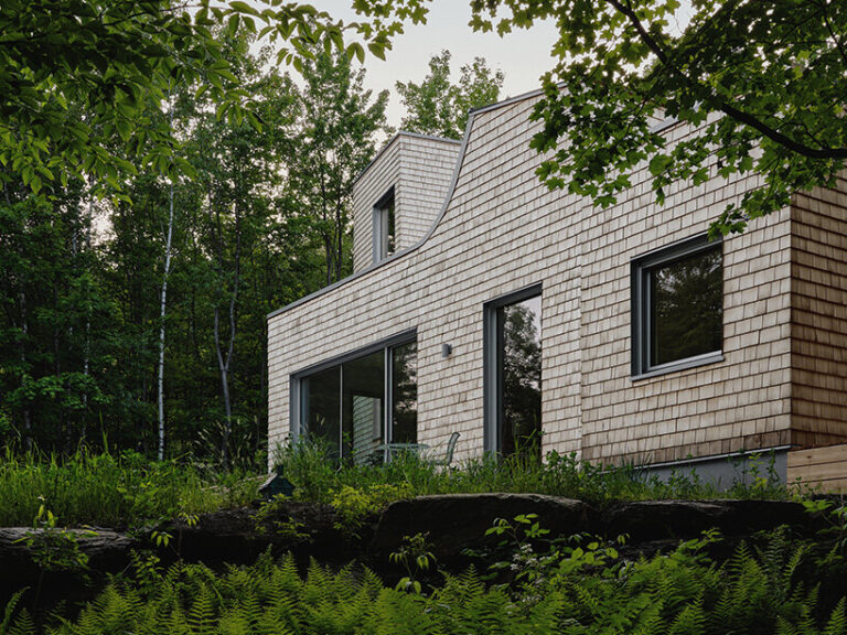 cedar shingle-wrapped 'waterhouse' dots forest clearing in quebec