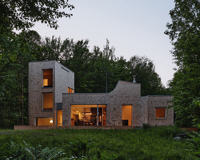 cedar shingle-wrapped 'waterhouse' dots a forest clearing in quebec