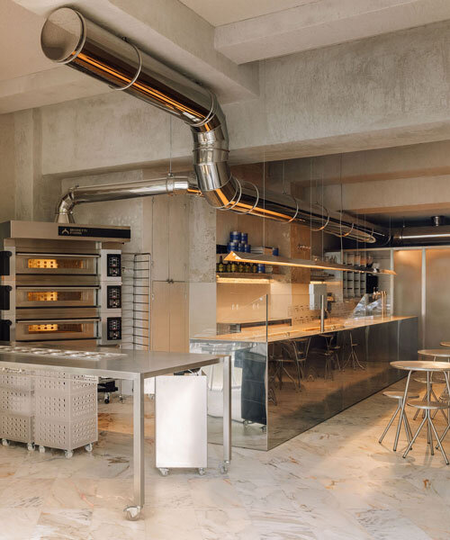 reflective steel interiors and open facade bring lisbon’s street activity into pizza restaurant