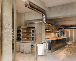 reflective steel interiors and open facade bring lisbon’s street activity into pizza restaurant