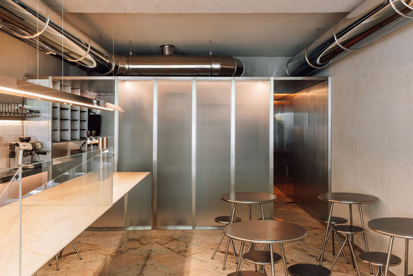 reflective steel interiors and open facade bring lisbon’s street activity into pizza restaurant