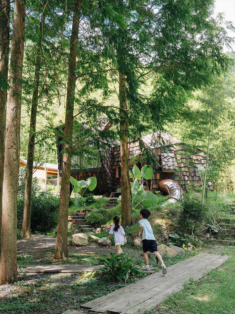 patchwork exterior of 'cat house' in china's anji forest is clad in discarded bamboo tiles