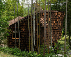 patchwork exterior of 'cat house' in china's anji forest is clad in discarded bamboo tiles