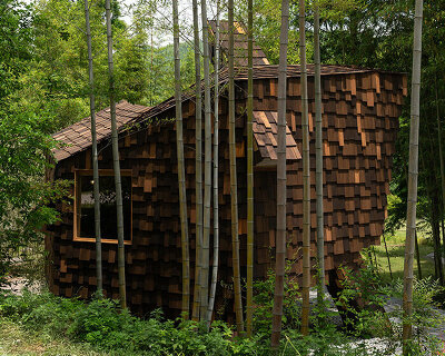 patchwork exterior of 'cat house' in china's anji forest is clad in discarded bamboo tiles
