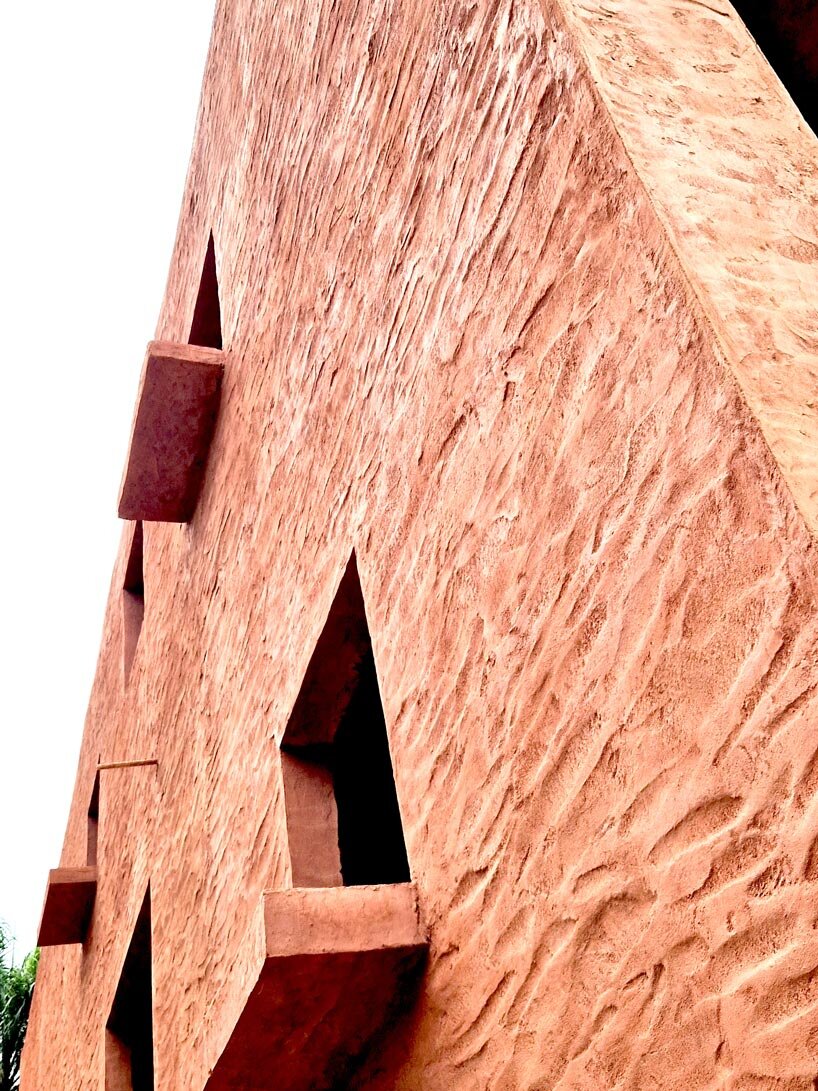 clay-pigmented monolithic villas emerge from ghana&rsquo;s red earth landscape