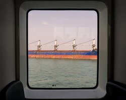 photographer captures cargo ships passing by on his ferry ride home