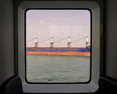 photographer captures cargo ships passing by on his ferry ride home