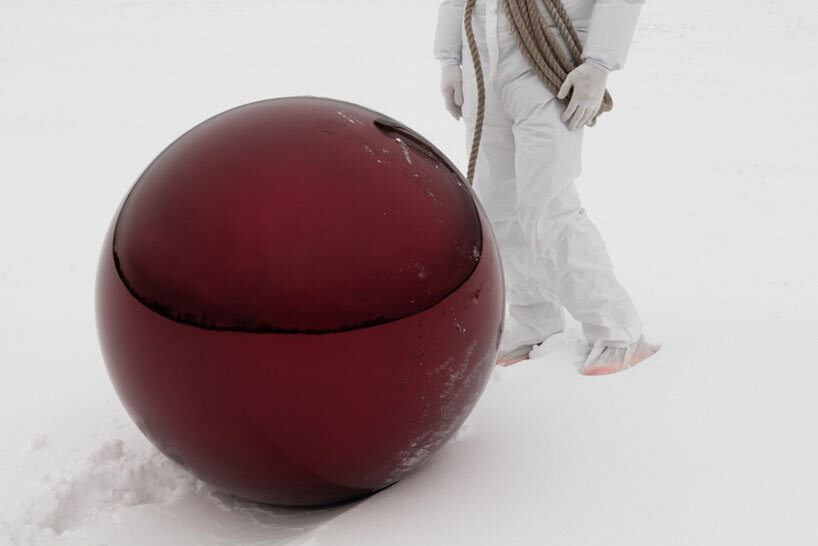 reflective red sphere suspends from tree in gregory orekhov&rsquo;s land art installation