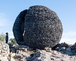 atelier yokyok sculpts sphere land installation out of black schist and granite in portugal