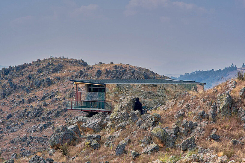 reflective glass surfaces mirror the rocky terrain across andean cabin by rtresarquitectos