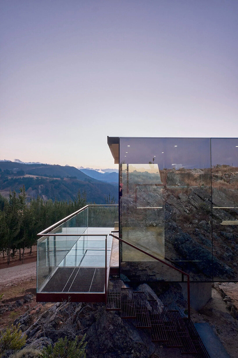 reflective glass surfaces mirror the rocky terrain across andean cabin by rtresarquitectos