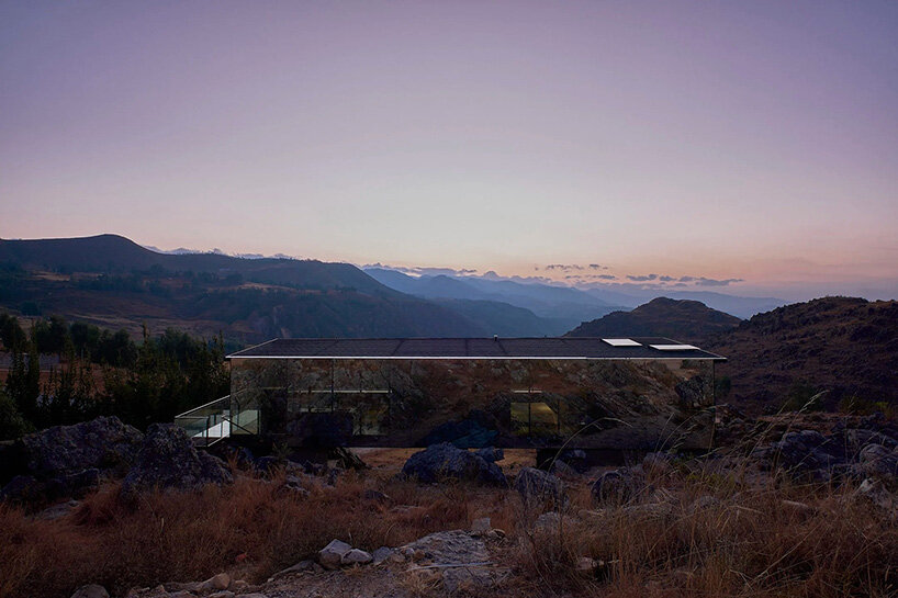 reflective glass surfaces mirror the rocky terrain across andean cabin by rtresarquitectos