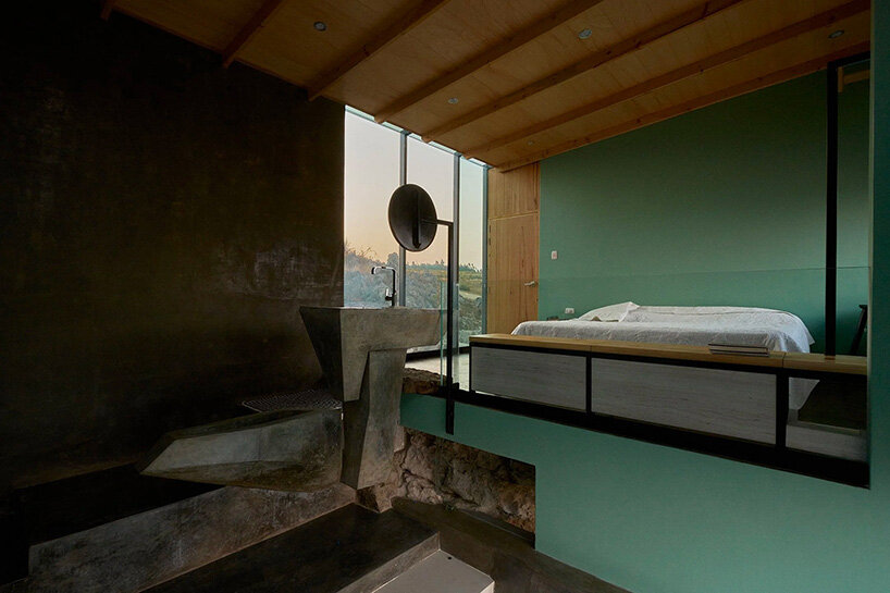 reflective glass surfaces mirror the rocky terrain across andean cabin by rtresarquitectos