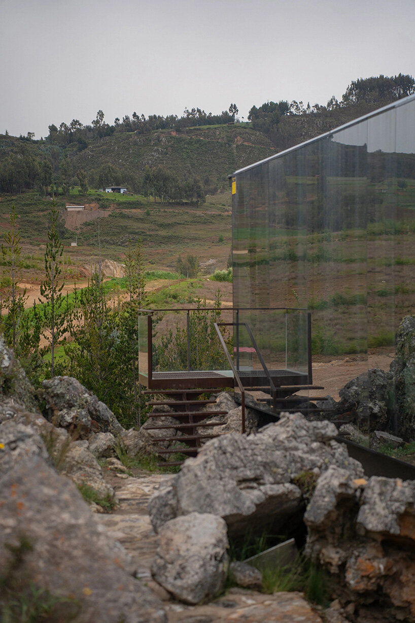 reflective glass surfaces mirror the rocky terrain across andean cabin by rtresarquitectos