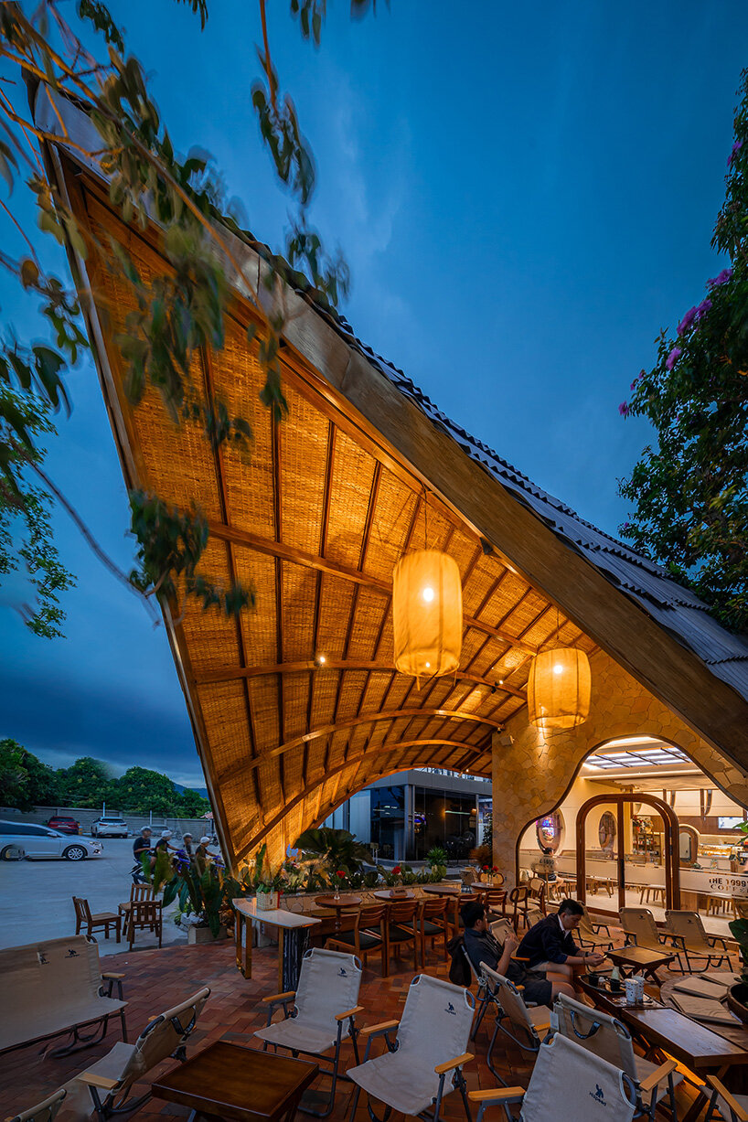 rippling metal roof drapes over interlocking stone volumes of vietnamese caf&eacute;