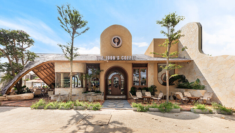 rippling metal roof drapes over interlocking stone volumes of vietnamese caf&eacute;