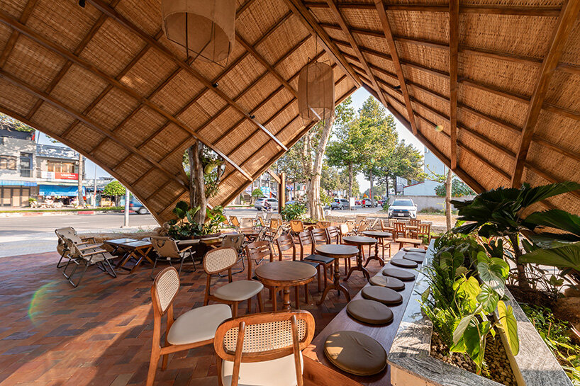rippling metal roof drapes over interlocking stone volumes of vietnamese caf&eacute;