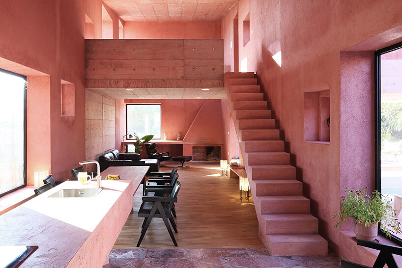 square openings punctuate the facade of courtyard-centric red house in albania