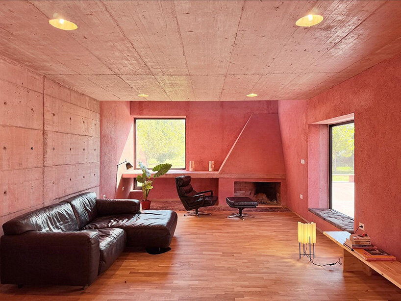 square openings punctuate the facade of courtyard-centric red house in albania