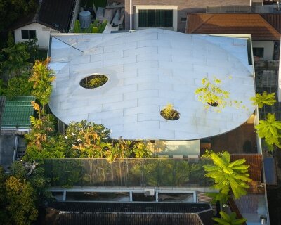 curved glass atriums penetrate residence’s aluminum roof in bangkok