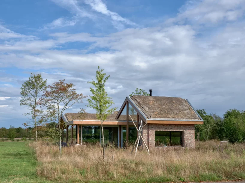 single draped roof unites brick, wood, and glass for teamtonbo house in the netherlands