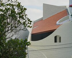 curved cutouts sculpt fluid voids within gabled residence in vietnam