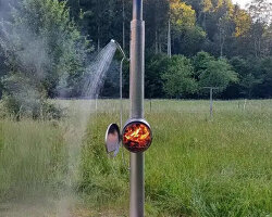 garden shower made of steel uses integrated wood stove to heat up the water