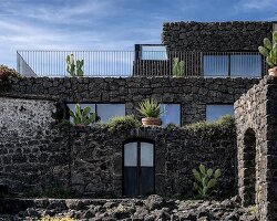 lava stone and old fisherman's house merge into contemporary villa on sicilian coast