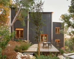 lightweight timber house in spain interlaces three raised volumes within tree canopy
