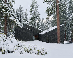 cedar-clad 'staggered cabin' by mork-ulnes steps down a forested slope above lake tahoe