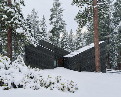 cedar-clad 'staggered cabin' by mork-ulnes steps down a forested slope above lake tahoe
