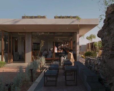 open planted courtyard organizes a café carved directly into rock in saudi arabia
