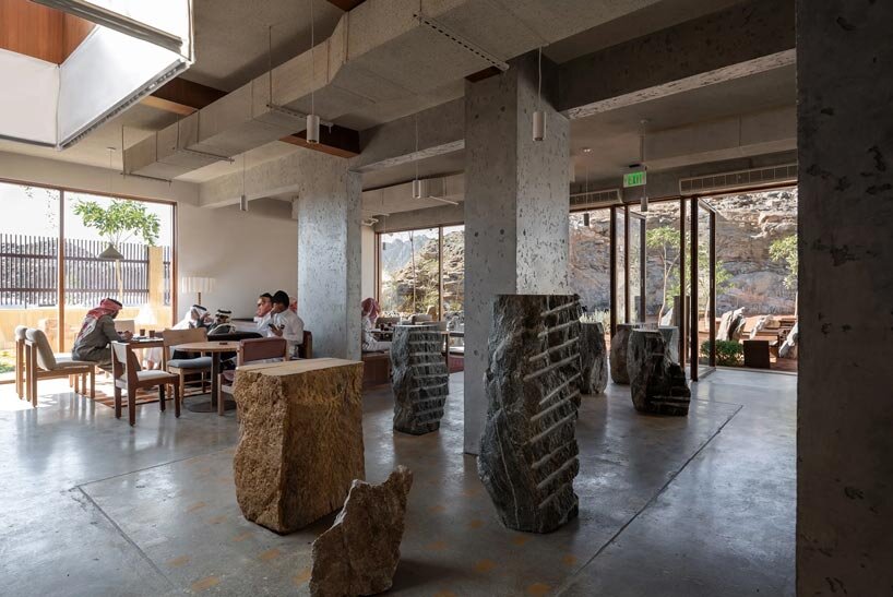open planted courtyard organizes a caf&eacute; carved directly into rock in saudi arabia