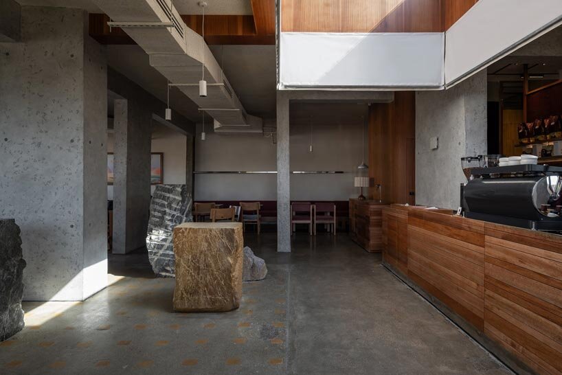 open planted courtyard organizes a caf&eacute; carved directly into rock in saudi arabia