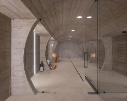 barrel-vaulted concrete cellar organizes vineyard building in poland