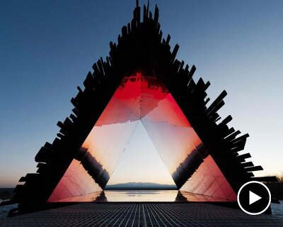 reflective red chamber emerges from prism mountain shelter’s charred wood shell