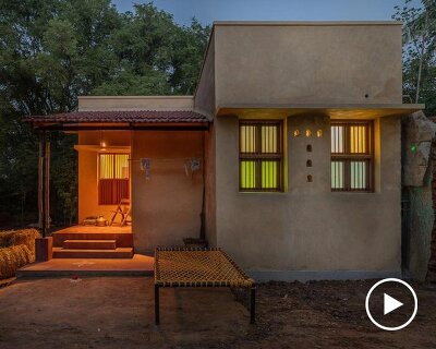 thousands of reclaimed bricks shape rural residence amid agricultural fields in india