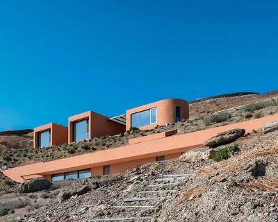olen resort embeds into greek island slope across three terraced levels