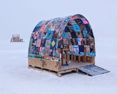 a quilt-wrapped ice shanty brings patchwork colors to a frozen minnesota lake