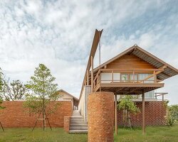 brick and concrete sculpt elevated riverfront residence in thailand by bodinchapa architects