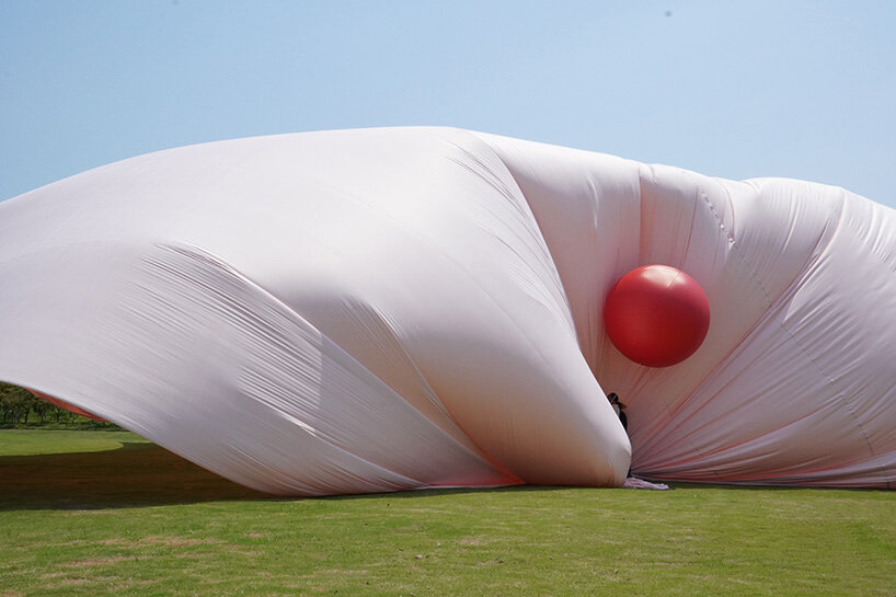 red balloons lift flowing fabric into a wedding playground by suki+partners in china - 3