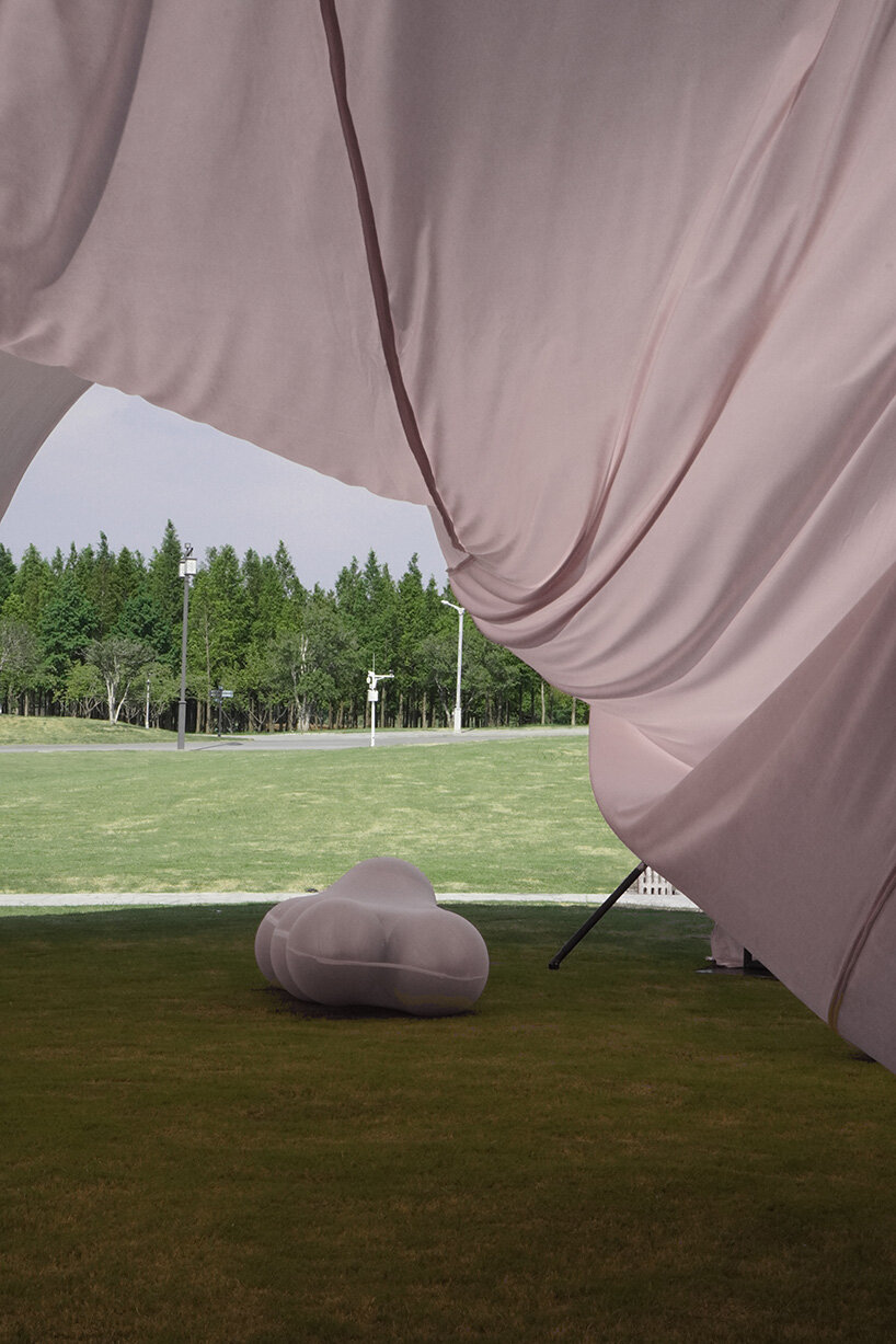 red balloons lift flowing fabric into a wedding playground by suki+partners in china - 11