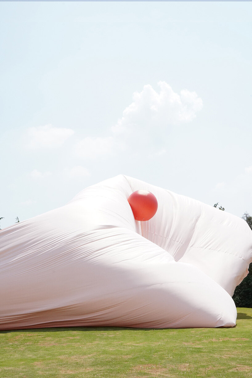 red balloons lift flowing fabric into a wedding playground by suki+partners in china - 5