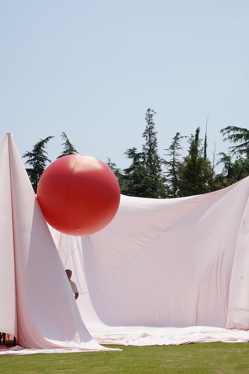 red balloons lift flowing fabric into a wedding playground by suki+partners in china - 6