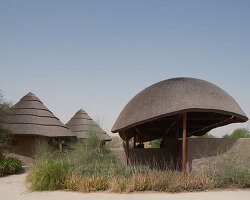 urko sánchez reinterprets african vernacular architecture in UAE with thatched pavilions