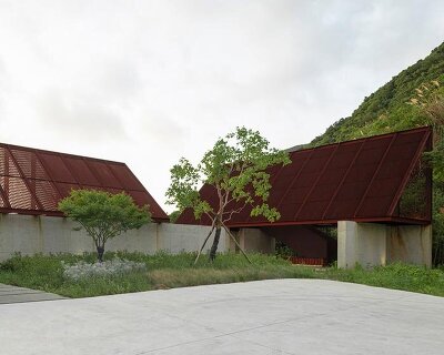 corten-clad twin pavilions frame shifting sea views along chinese coastal valley