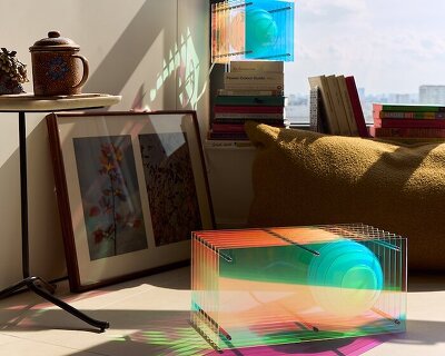 sculptural lamp transforms acrylic, inox, and opal glass into glowing, iridescent light object